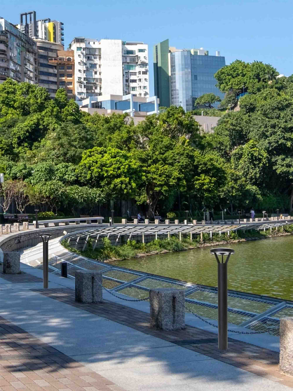 Solar LED bollard lights along a waterfront pathway in an urban park.